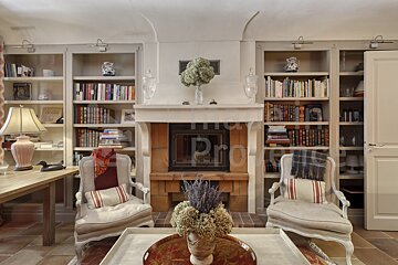 A living room with two chairs and a fireplace with a sign that says provence