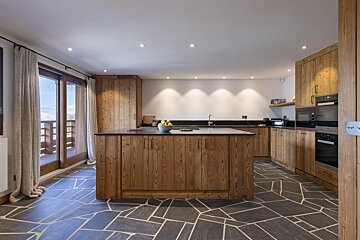 A kitchen with wooden cabinets and black counter tops
