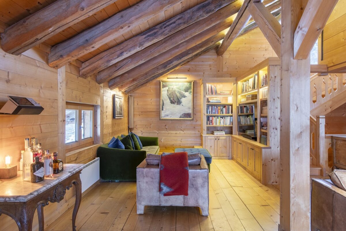 A living room with a green couch and a painting on the wall