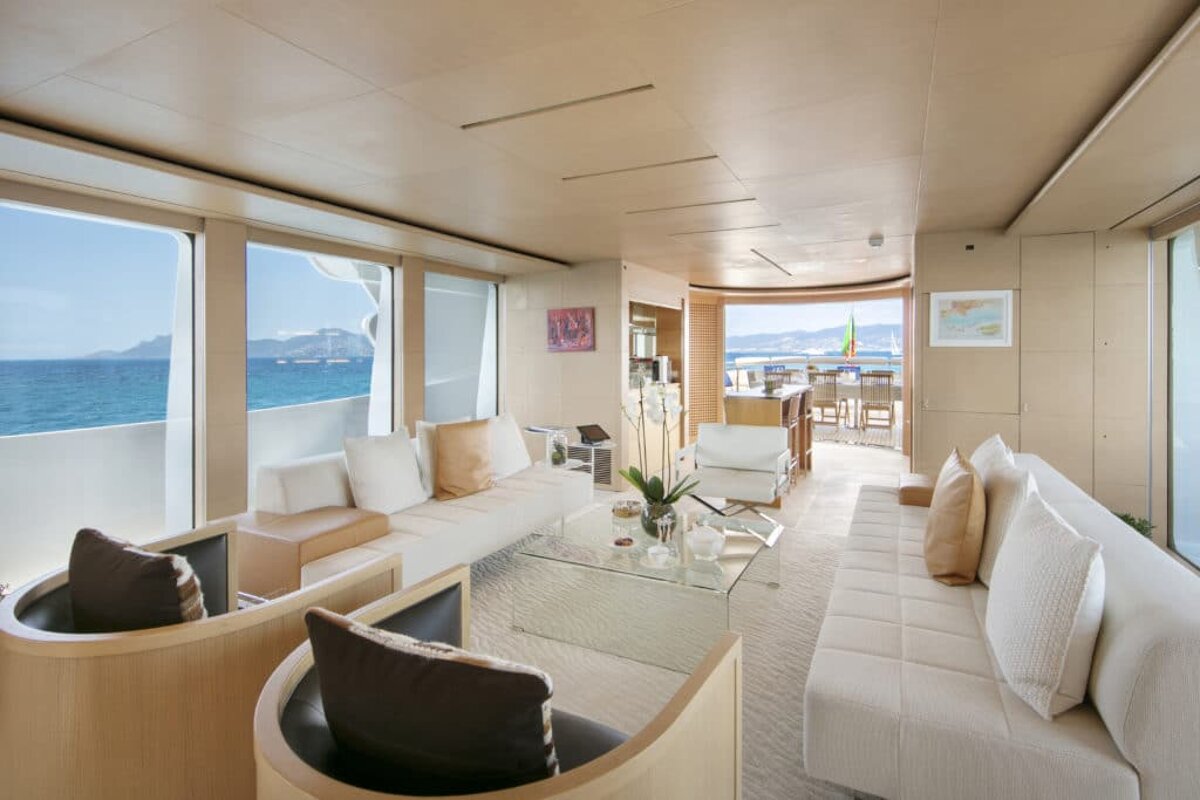 A living room with a couch and a table with a view of the ocean