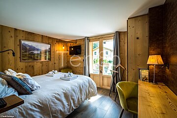 A bedroom with a large bed and a picture on the wall that says te