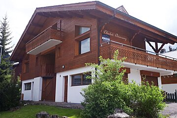 A chalet for sale with a sign on the side