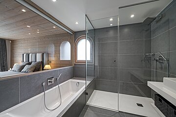 A bedroom with a king size bed and a walk in shower