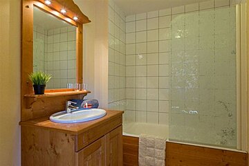 A bathroom with a sink a mirror and a bathtub