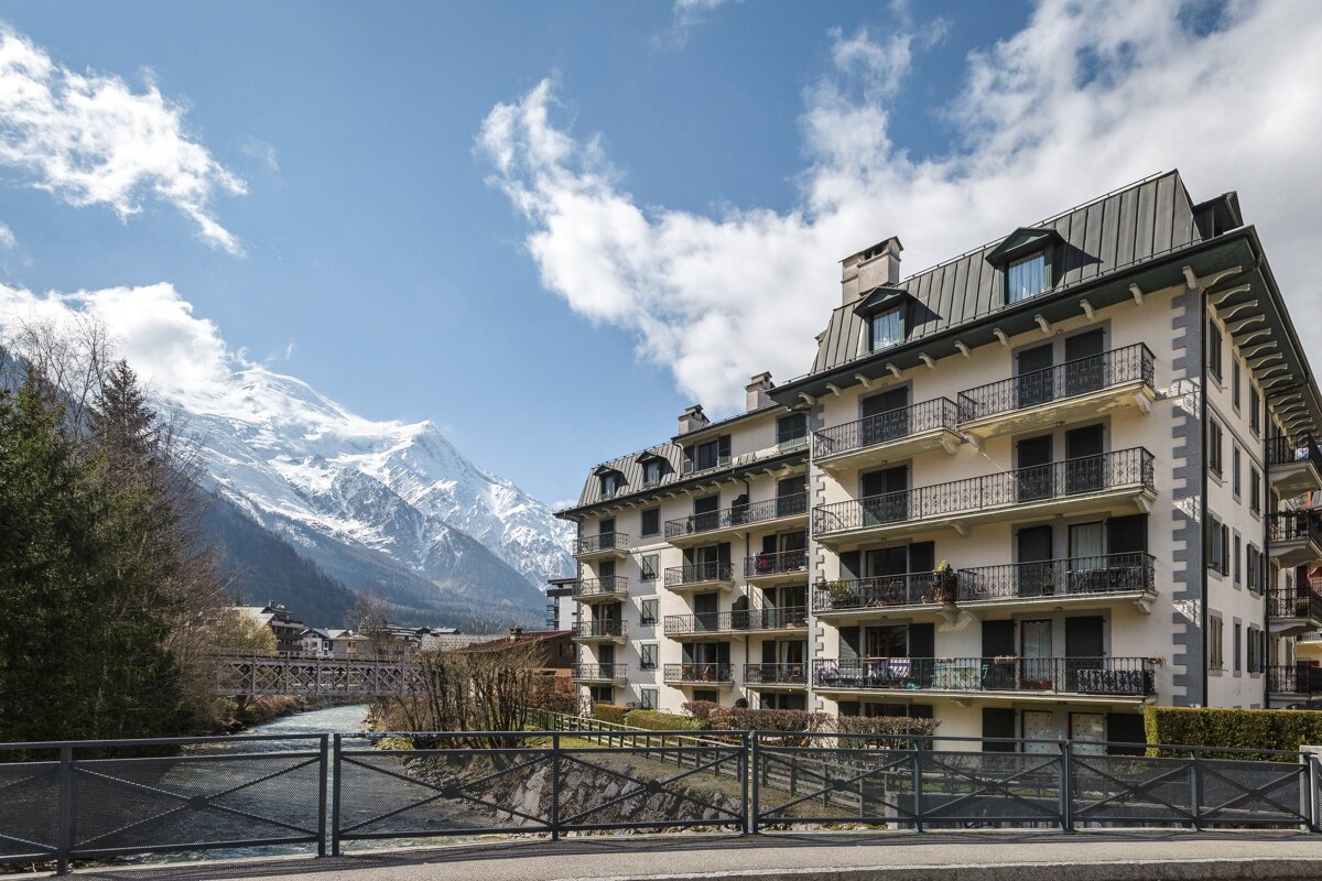 A building with balconies and a mountain in the background
