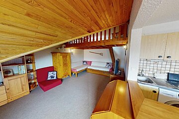 A living room with a couch and a kitchen