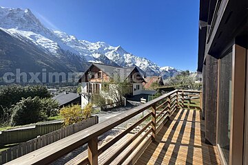 A balcony with a view of snowy mountains and the words chximmo on the bottom