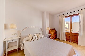 A bedroom with a large bed and a dresser