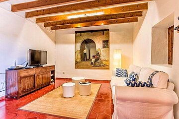 A living room with a painting on the wall above the couch