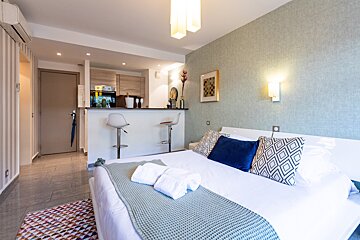A bedroom with a white bed and blue pillows