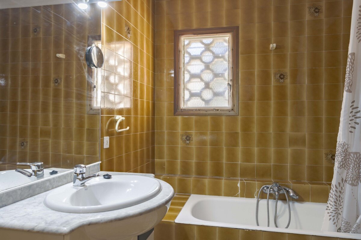 A bathroom with a sink a tub and a window