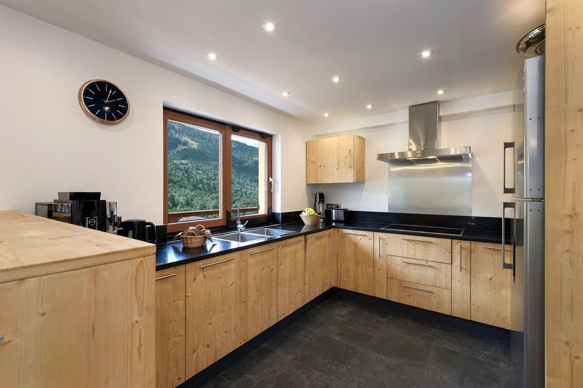A kitchen with wooden cabinets and black counter tops