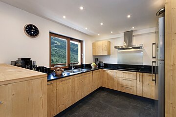 A kitchen with wooden cabinets and black counter tops