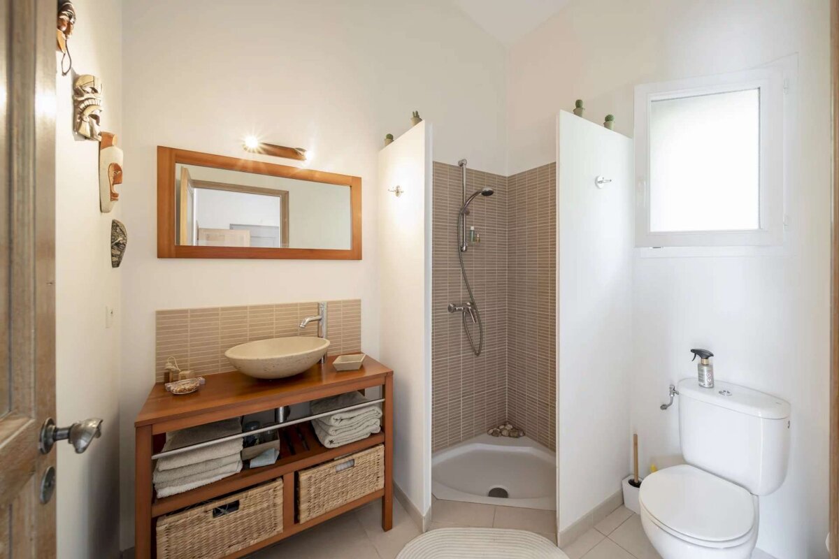 A bathroom with a toilet a sink and a mirror