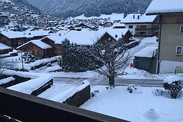 A snowy landscape with houses and trees covered in snow