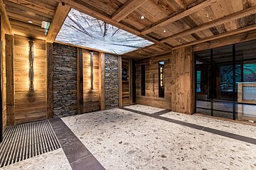 A hallway with wooden walls and a ceiling with trees on it