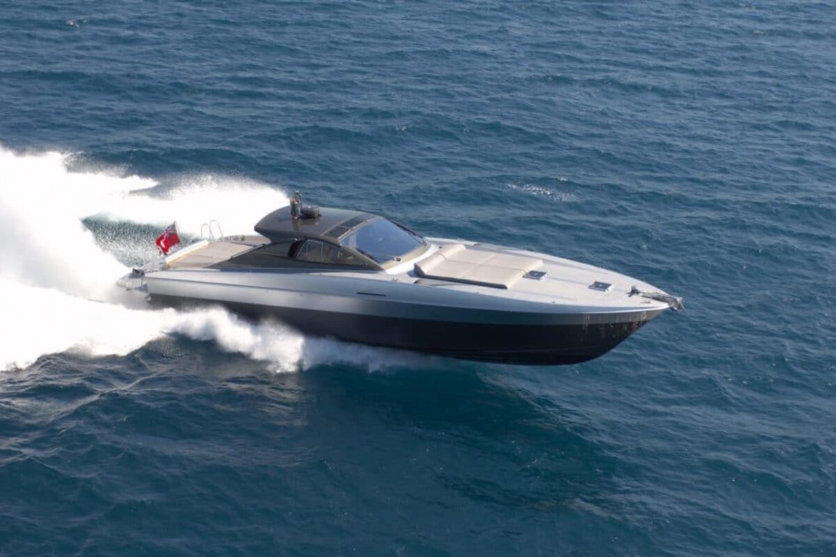 A boat with a red flag on the side is going through the ocean