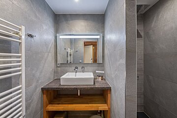 A bathroom with a square sink and a mirror