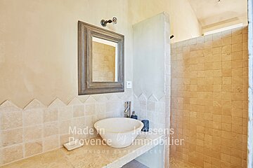 A bathroom with a sink and a mirror made in provence by immobilier