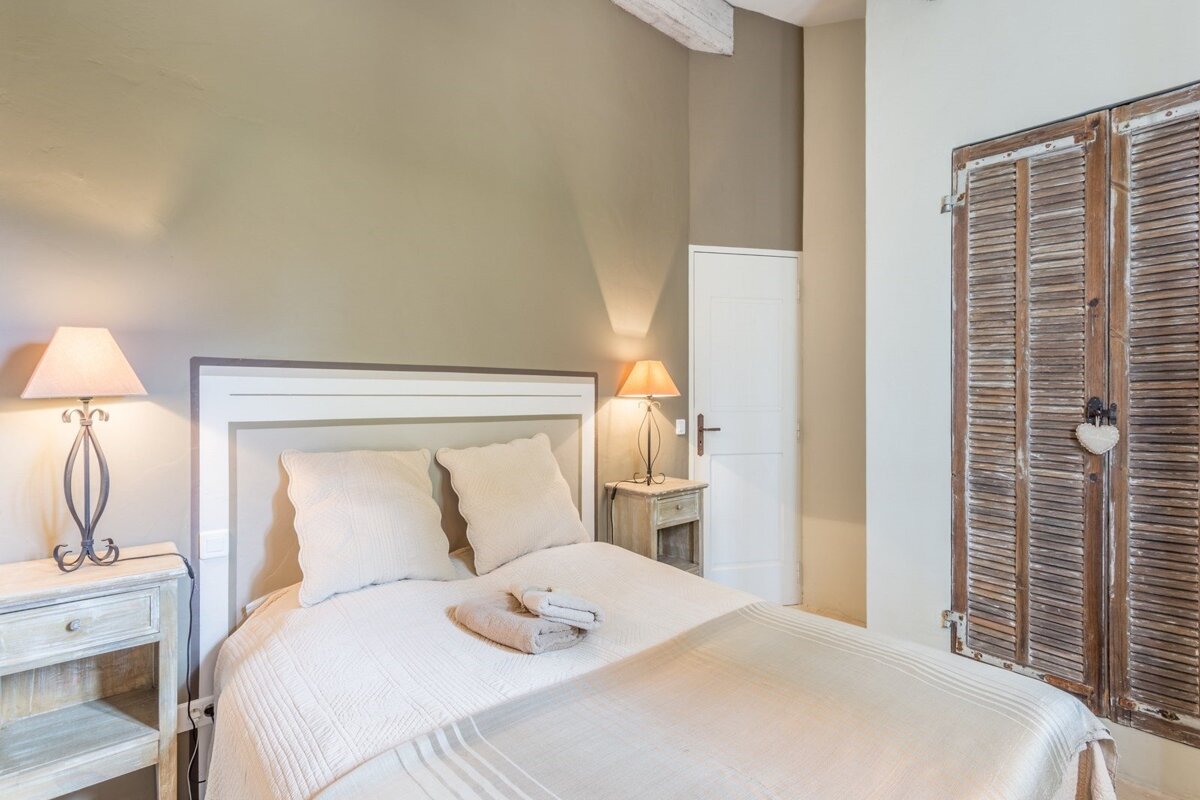 A bedroom with a bed and two lamps