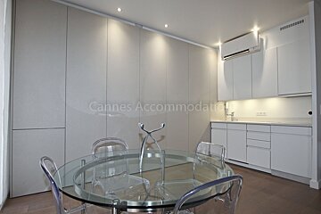 A kitchen with a glass table and chairs and the words cannes accommodations on the wall