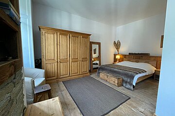A bedroom with a bed and a chair in it