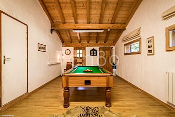 A pool table in a room with the number 80 on the wall