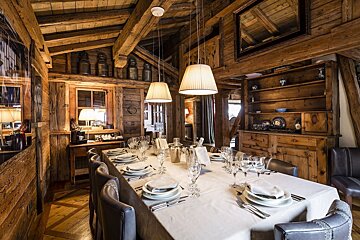 A dining room with a long table and chairs