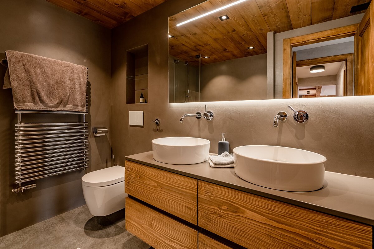 A bathroom with two sinks and a toilet