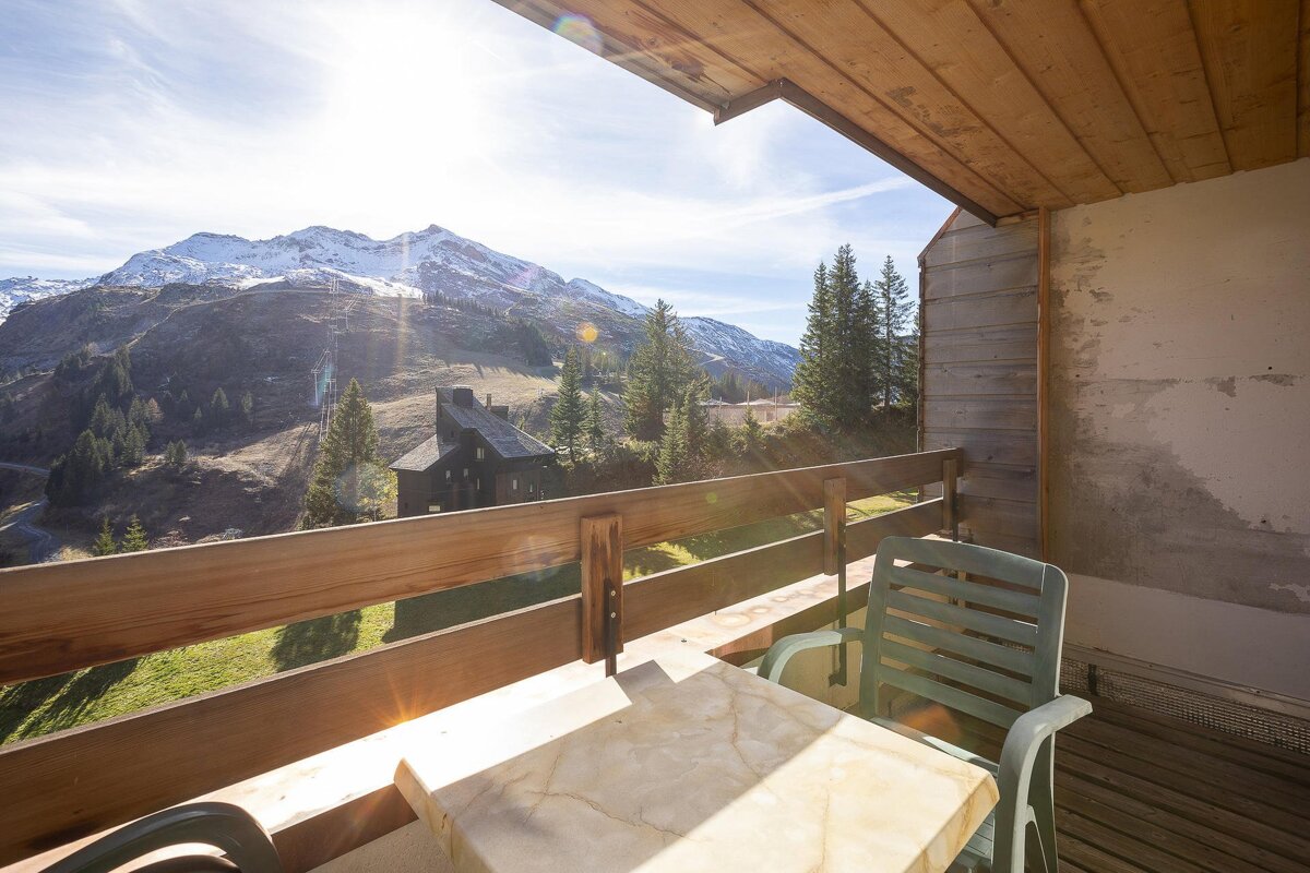 A balcony with a view of mountains and trees