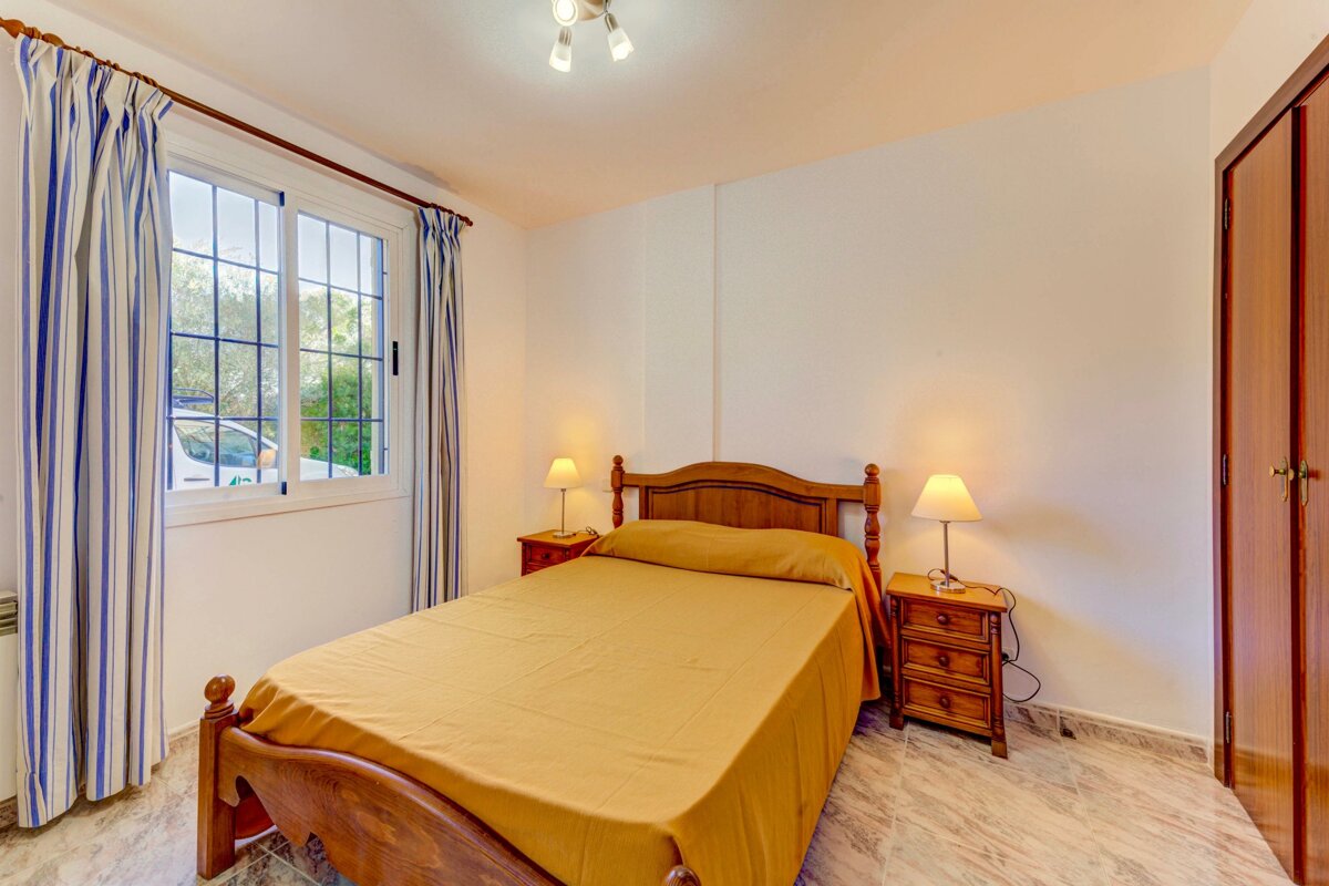 A bedroom with a bed and two nightstands