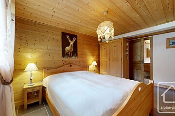 A bedroom with a painting of a deer on the wall