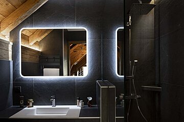 A bathroom with a sink a mirror and a shower head