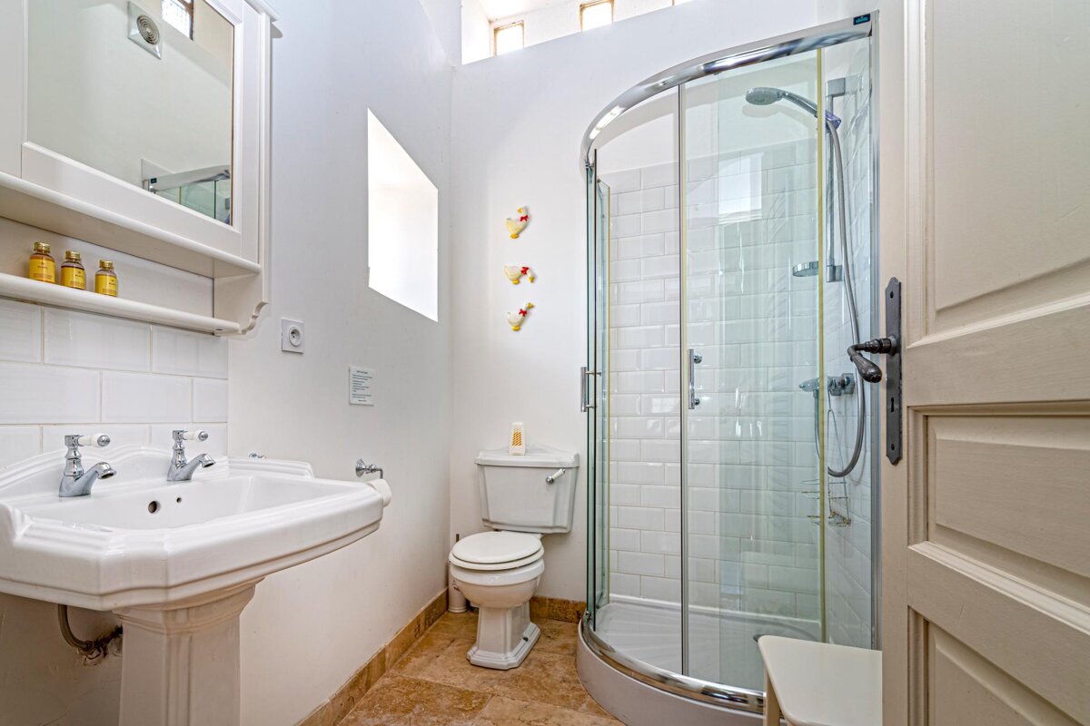A bathroom with a toilet a sink and a shower