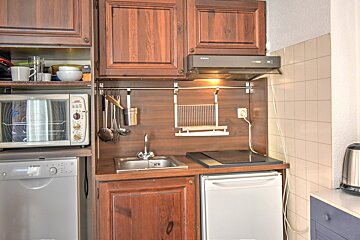 A bathroom with brown tiles and a sink and toilet