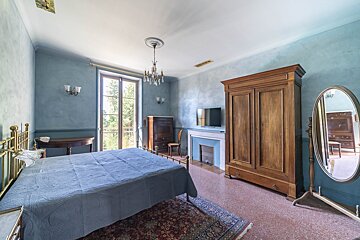 A bedroom with a large bed and a mirror