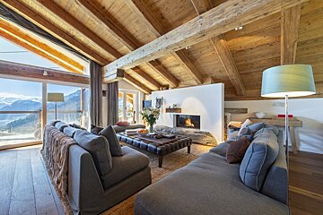 A living room with a fireplace and mountains in the background