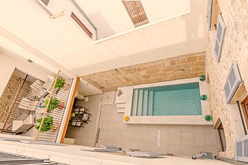 An aerial view of a swimming pool between two buildings