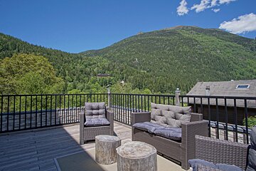 A balcony with a view of mountains and trees