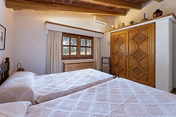 A bedroom with two beds and a wooden wardrobe