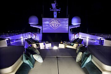 A large screen displays a logo for warner bros