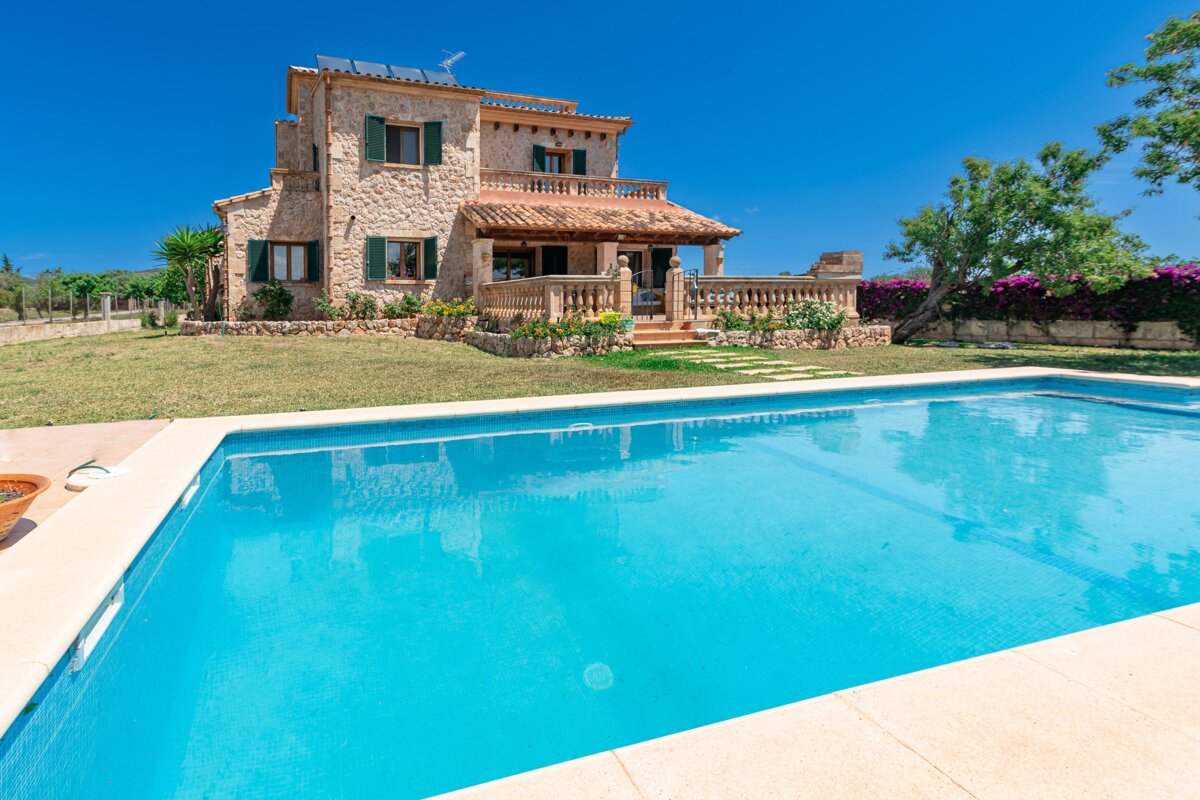 A large house with a swimming pool in front of it