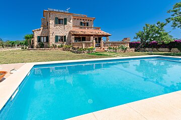 A large house with a swimming pool in front of it