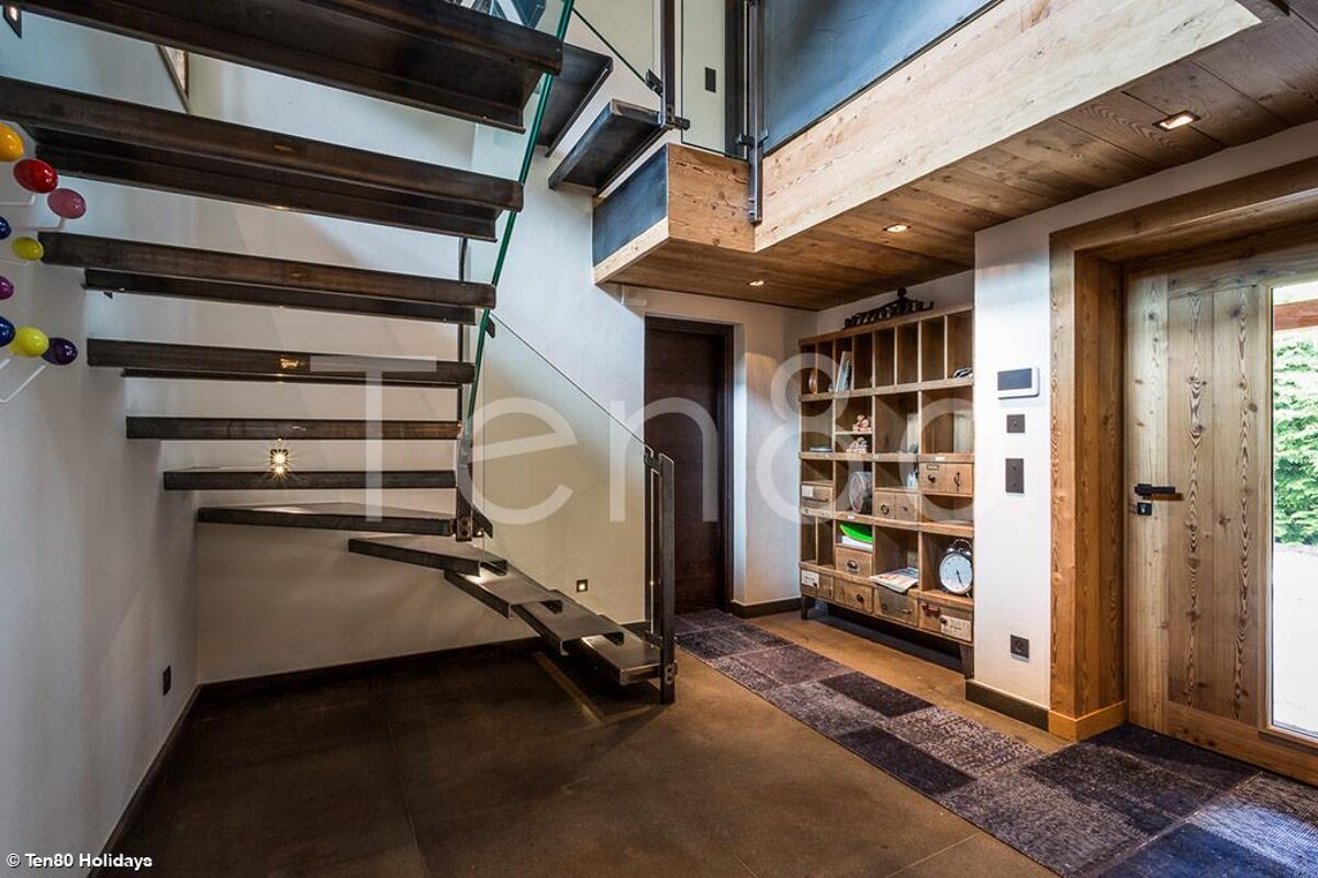 A hallway with a staircase and a sign that says ten80 holidays