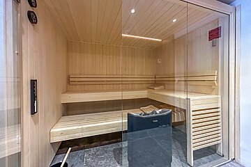 A sauna with a clock on the wall and a sign that says ' tcm ' on it
