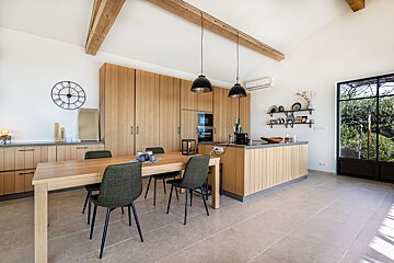 A kitchen with wooden cabinets and a clock on the wall