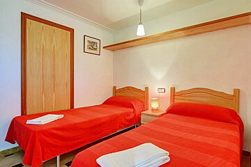A bedroom with two beds and a picture on the wall