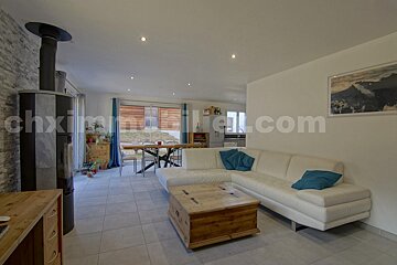 A living room with a couch and a coffee table and the website chximmobilier.com