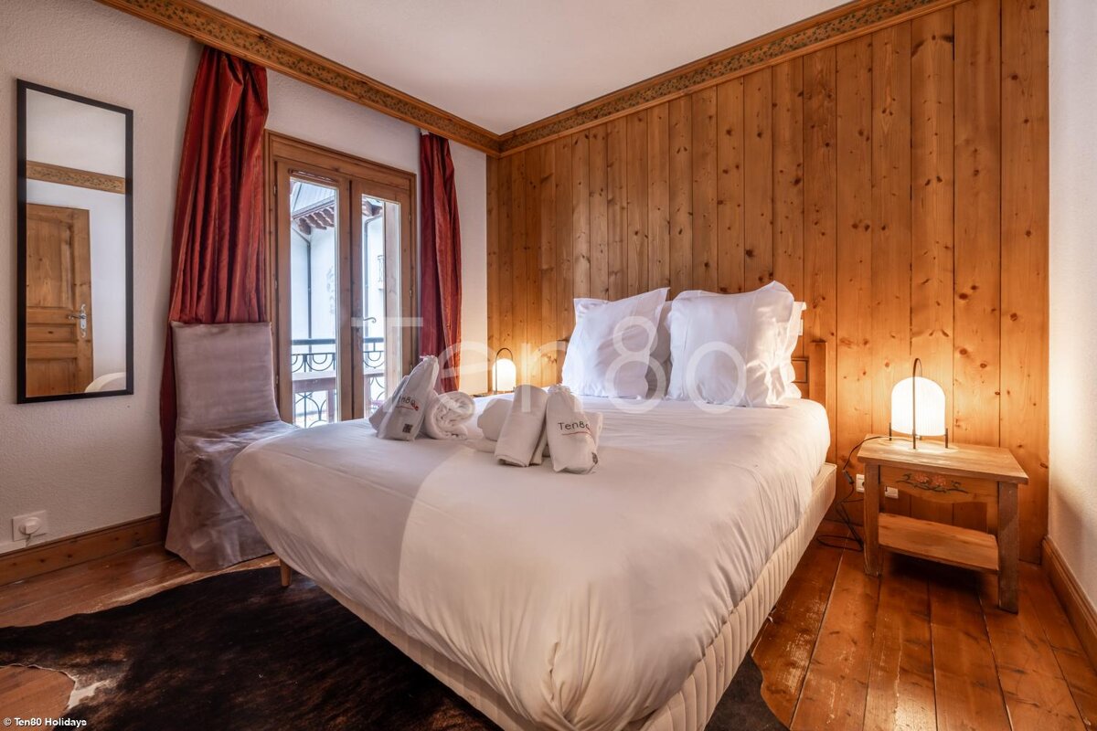 A bedroom with wood paneling and a bed that says tahiti on it