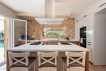 A kitchen with a large island and a stove top oven